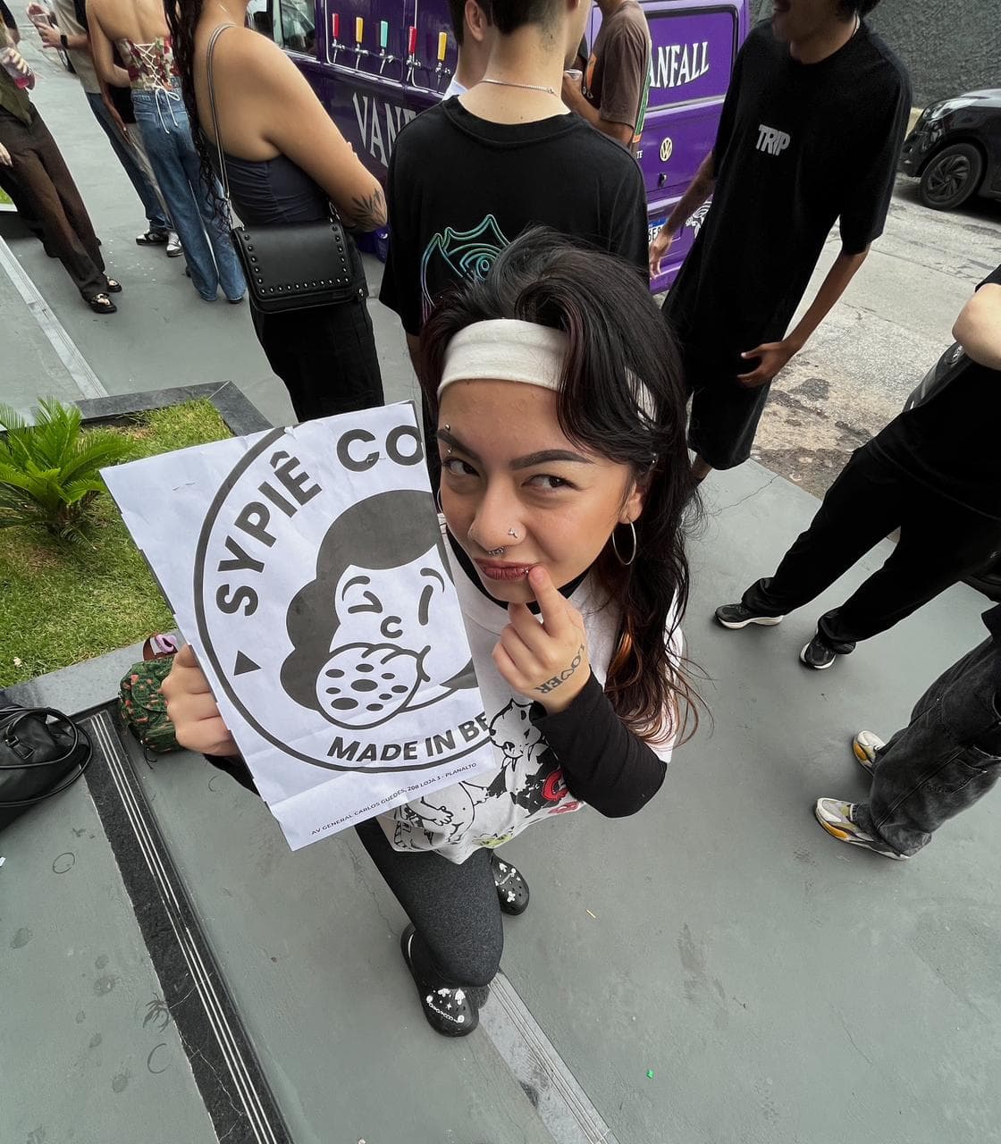 Cliente sorrindo e segurando a sacola da Sypiê Cookies na rua